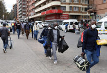 assengers wearing masks walk to a taxi rank as residents of a number of African countries where coronavirus is spreading