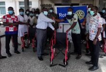 • Mr Quayson (third from right) presenting the wheel chairs to Dr. Kwarteng