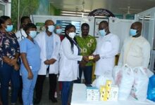 Dr Kwaku Agbesi (second from right) presenting the items to Dr Gobodzo while staff and alunini members look on