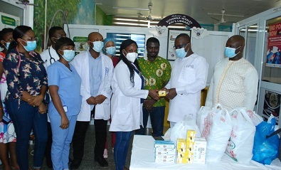 Dr Kwaku Agbesi (second from right) presenting the items to Dr Gobodzo while staff and alunini members look on