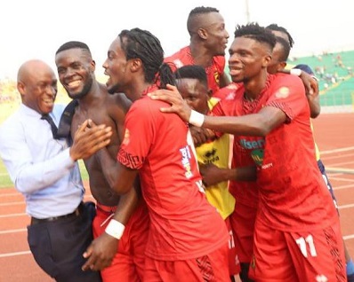 Kotoko's Mfegue (shirt off) being mobbed by team-mates after scoring