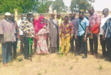 Mr Banuoku (left in a blue nose mask) with a shovel in hand doing the symbolic sod cutting together with some stakeholders at the ceremony