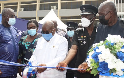 President Akufo-Addo(middle)being assisted by Mr Ambrose Dery (right) and Dr Dampare (second from right)to cut the tape to commission the Virtual Medical Center Photo Anita Nyarko-Yirenkyi