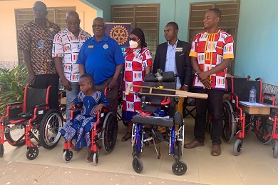 Mr Kala (second from left) and some members of the Rotary Club posed with a beneficiary after assisting her to mount the wheelchair.