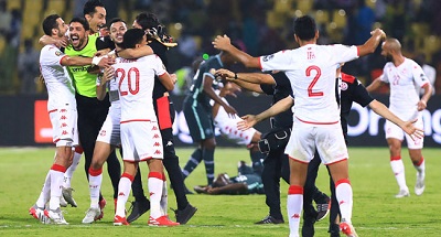 Tunisia celebrating their win, while some Nigerian players (background) crumble on the turf after the game