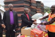 The Moderator, Rt. Rev. P.S. Dzomeku presenting the items to Mr Louis Afful, the Municipal NADMO director