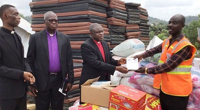 The Moderator, Rt. Rev. P.S. Dzomeku presenting the items to Mr Louis Afful, the Municipal NADMO director