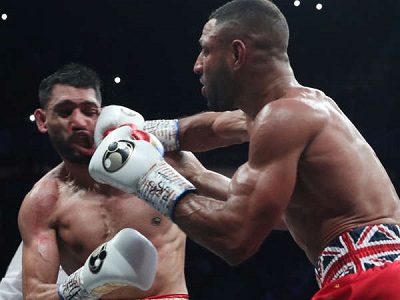 Brooks (right) hammering Khan in their grudge fight at the weekend
