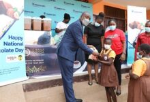 Mr Ebow Quayson presenting a bar of chocolate to one of the pupils