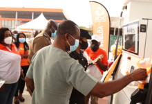 • Mr Prempeh with microphone being assisted by other dignitaries to cut the tape to commission the newly refurbished Kwabenya Roundabout GOIL Service Station