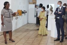 The head of the MST, Ms AkosuaSaahBuckman (hand stretched), showing patrons the exhibits