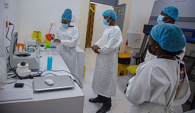 A nurse demonstrating how the PCR works while other dignitaries look on