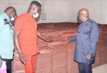 Dr Kwaku Adjepong (middle) CEO Dophil Roofing showing Dr Kwaku Afriyie,(right) some of the Ecophil Roofing Tiles. Photo Godwin Ofosu-Acheampong