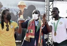 Senegal President Sall (centre) sandwiched between Coach Cisse (left) and Captain Kalidou Koubaly, holding the AFCON trophy