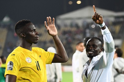 Mane (left) and goalkeeper Edouard Mendy waving to the crowd after beating Burkina Faso