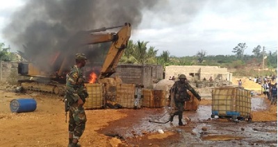 Soldiers set an excavator on fire