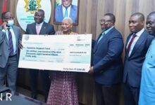 Sulemana Koney, CEO of Ghana Chamber of Mines (second from left) presenting one of the dummy Cheques to the Committee members.