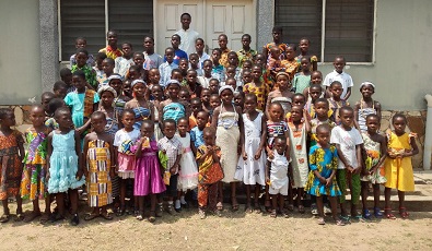 The children in a group photograph with Rev Fr Anthony Delaali Azah