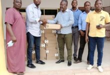 Mr Ajilore (second left) present the items to Mr Okwaisei(fourth from right)