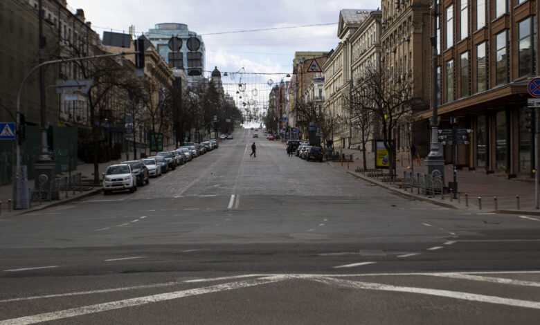 A man walks across what would normally be a busy road during the curfew in Kyiv, Ukraine, on March 27. (Ty O'Neil/SOPA Images/LightRocket/Getty Images)