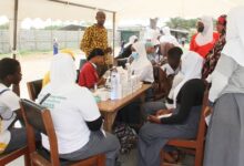 Students going through a health screening conducted by old students