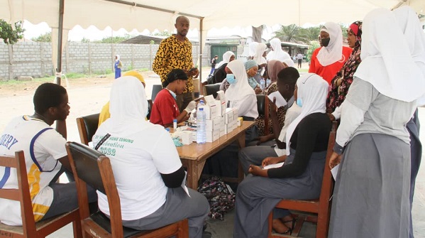 Students going through a health screening conducted by old students