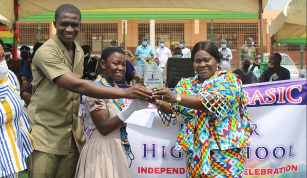 Ms Owusu-Ahenkorah(right) presenting the overall best prize to a pupil of Abelenkpe Basic school