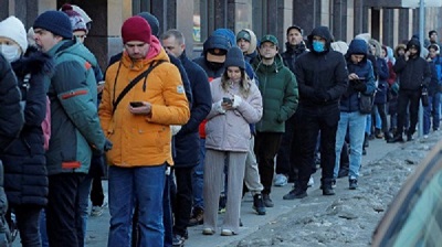 People stand in line to use an ATM money machine in St Petersburg on Sunday