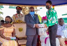 President Akufo-Addo (in suit) presenting books to a student of St. Augustine's College at Cape Coast