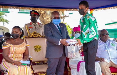 President Akufo-Addo (in suit) presenting books to a student of St. Augustine's College at Cape Coast