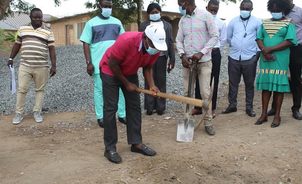 Mr Moses Anim cutting sod for the start of the project
