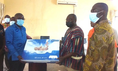 Mr Martin Adjei Mensah Korsah (middle) presenting a medical equipment to Dr Kwabena Fosohene Kusi, Municipal Health Director with Mr Benjamin Yaw Gyarko (right)