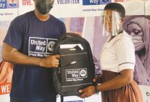 MrKissiedu presenting a school bag to one of the beneficiaries