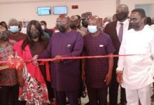 Dr Mahamudu Bawumia (middle) cutting tape to open the facility