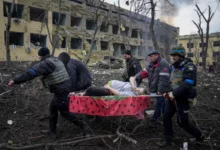 An injured pregnant woman is carried away from the damaged maternity hospital in Mariupol