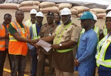 Captain Afadzi (third from right) presenting truckload of cement bags to Emmanuel Afful, staff of National Disaster Management Organisation,NADMO