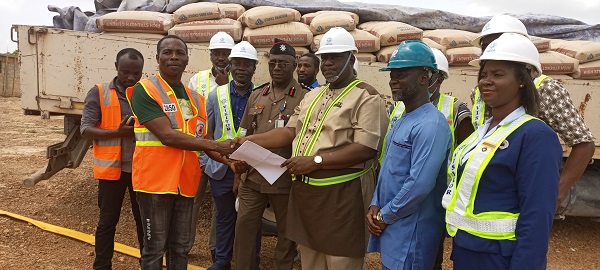 Captain Afadzi (third from right) presenting truckload of cement bags to Emmanuel Afful, staff of National Disaster Management Organisation,NADMO
