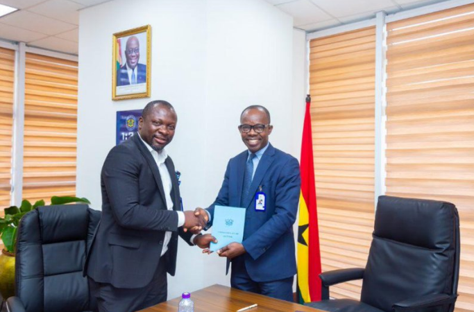 Mr Awuah exchanging a document with Dr Antwi-Boasiako