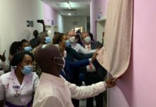 Dr Ali Samba (in suit and with microphone) being assisted by members of Lions International and family members to unveil the plaque in Mrs Tay’s honour Hospital staff and other dignitaries after the ceremony
