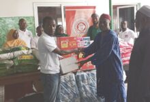 Imam Seth (left) presenting the items to Mallam Musah. Looking on are members of the GAMP