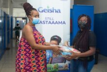 Brand Manager of Geisha Unilever Judy Adda (right) making a presentation to a beneficiary at the Korle-Bu Hospital