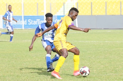 Man-of-the-Match Kwesi Donsu shields the ball away from Oly's midfielder, Ibrahim Sulley (in blue) Photo Raymond Ackumey
