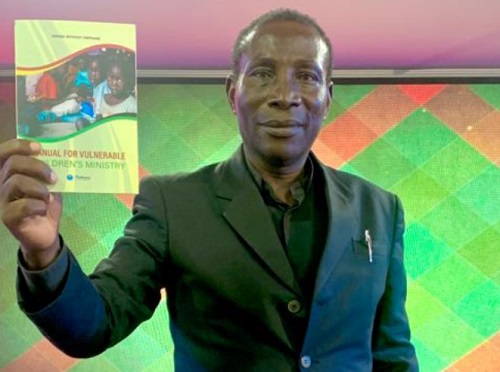 Reverend Richmond Tettey displaying a copy of the manual at the launch