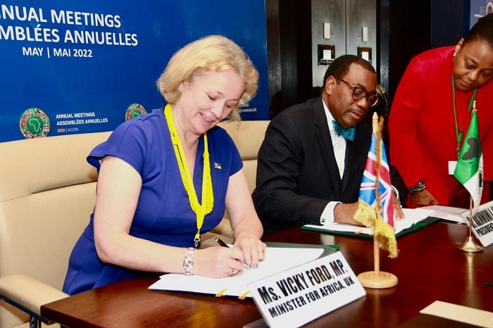 Ms Ford signing a document alongside Akinwumi Adesina, President of the AfDB