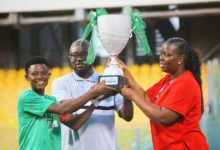 • Skipper Justice Ama Tweneboah (left) receives the league trophy from GFA President Kurt Okraku and chairperson of the WPL, Mrs. Hilary Boateng