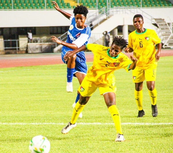 An Ampem Darkoa Ladies striker (in blue and white) attempts a shot at goal as a Togolese marker tries to block