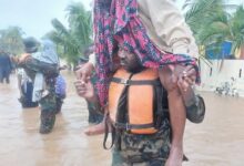 A military personnel helping an aged woman during the recent rainfal
