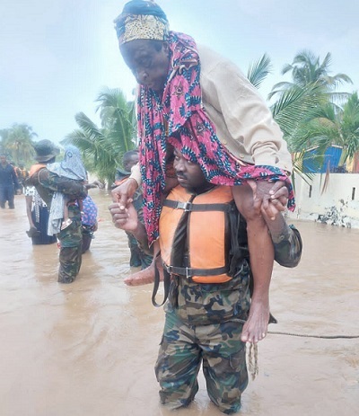 A military personnel helping an aged woman during the recent rainfal