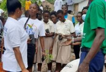 Mr Emmanuel Kyere (right) supervising a pupil to plant tree seedlings.