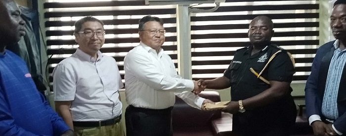 appre• Mr Tang (third from right) presenting the cash in envelope to ACP Owusu-Bempah